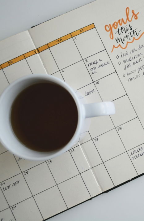 white-ceramic-mug-with-coffee-on-top-of-a-planner.jpg white ceramic mug with coffee on top of a planner